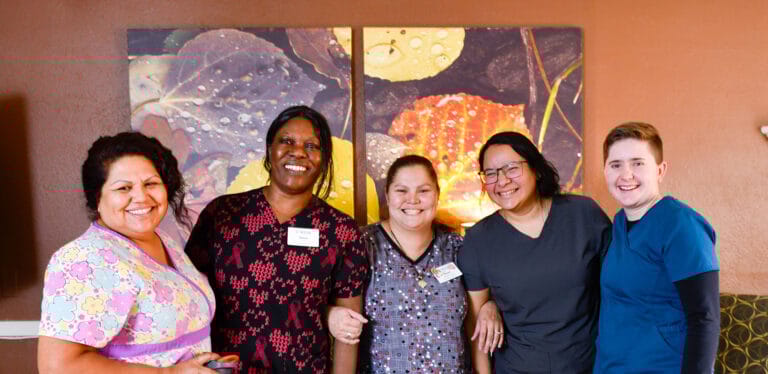 Staff members posing together in a community area