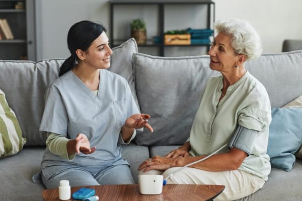 Nurse talking with elderly resident in a cozy living area