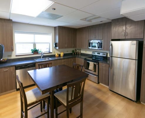 Modern kitchen area with wooden cabinets and appliances