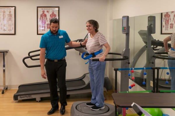 Staff assisting a resident in a rehabilitation area