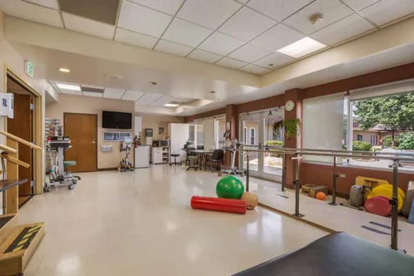 Physical therapy room with equipment and bright lighting