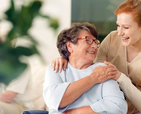 Staff member smiling with a resident in a common area