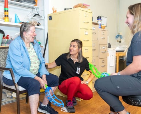 Staff assisting a resident in an activity room