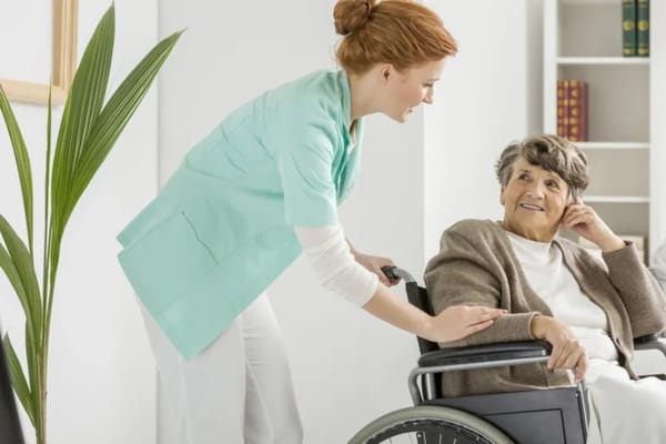 A caregiver assisting a resident in a wheelchair