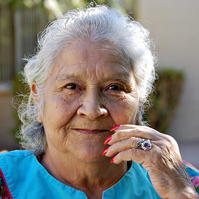 Senior woman smiling outdoors with a blue top
