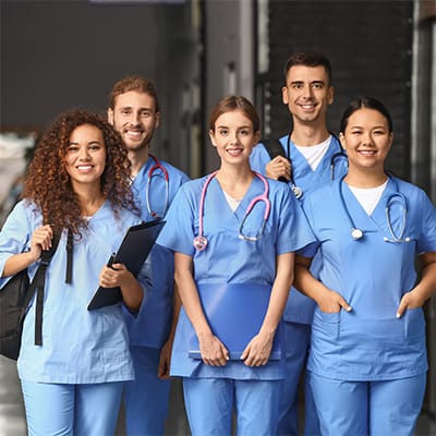 Group of healthcare staff in scrubs smiling