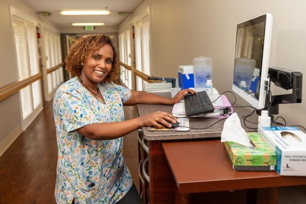 Staff member assisting at a desk in a hallway
