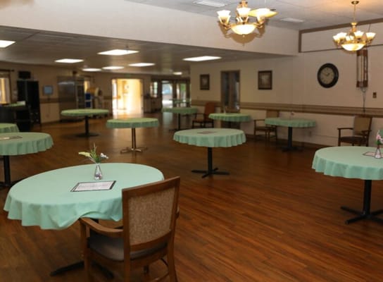 Dining room with tables and chairs set for residents