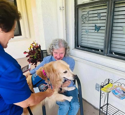 Resident interacting with a therapy dog outdoors
