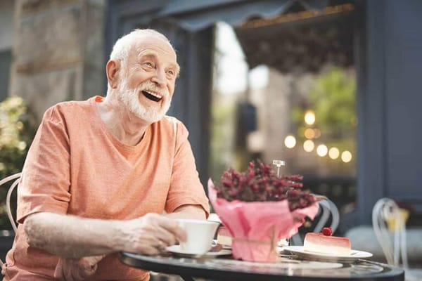 Elderly man enjoying tea and dessert outdoors