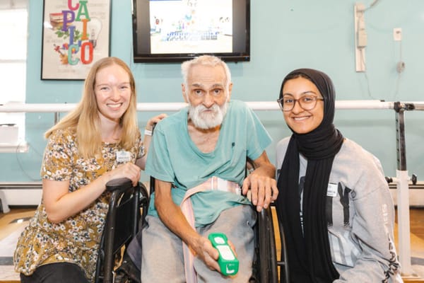 Staff members with a resident in an activity space