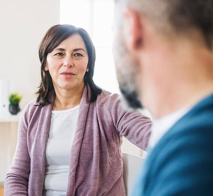 A woman engaging in conversation with another person