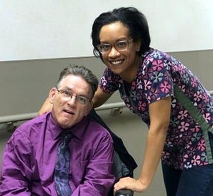 Staff member with a resident in a facility hallway
