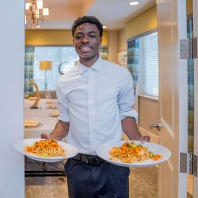Staff member serving food in a dining area
