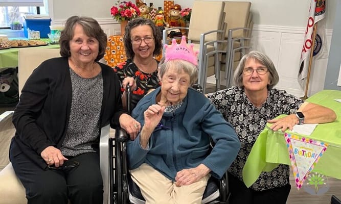Residents celebrating a birthday in an activities room