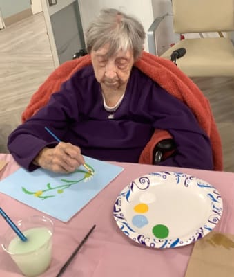 Elderly resident painting during an activity session