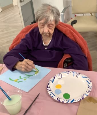 Elderly resident painting during an activity session