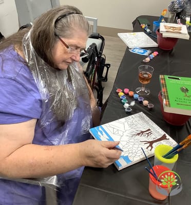 Resident painting during an art activity in the facility