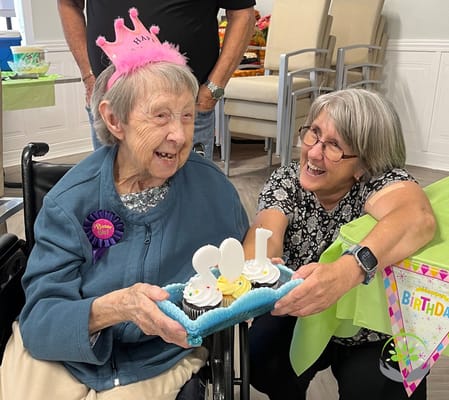 Resident celebrating a birthday with staff and cupcakes