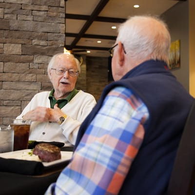 Two elderly men dining together in a restaurant