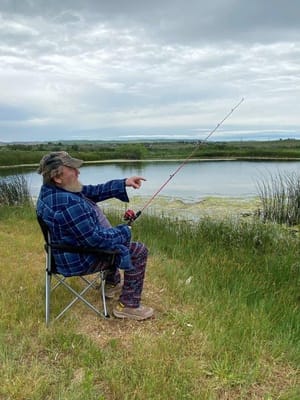 A man fishing by a peaceful lake