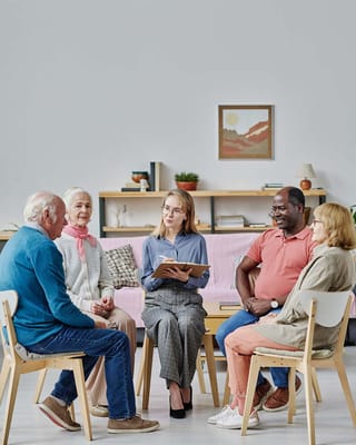 A group of residents engaged in a discussion with a staff member