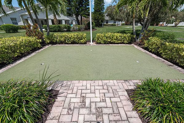 Outdoor putting green surrounded by landscaping