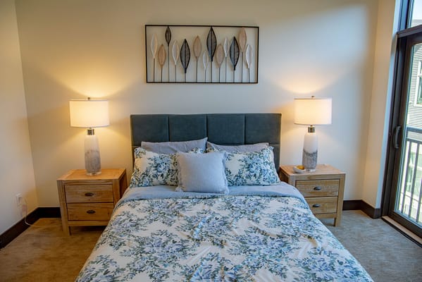A well-furnished resident room with a bed and decor