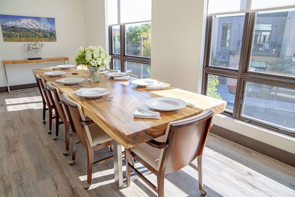 Bright dining room with a long wooden table and place settings