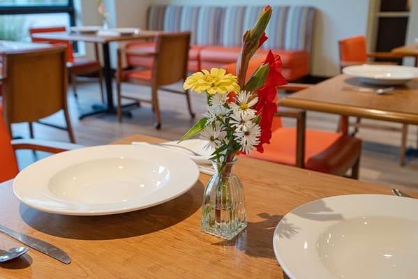 Dining table set with flowers and plates