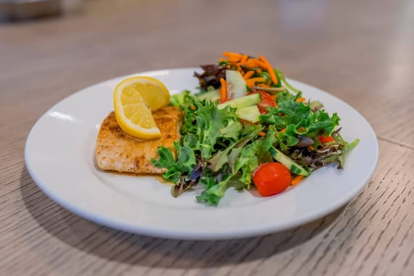 Plate of salmon with a fresh salad garnish