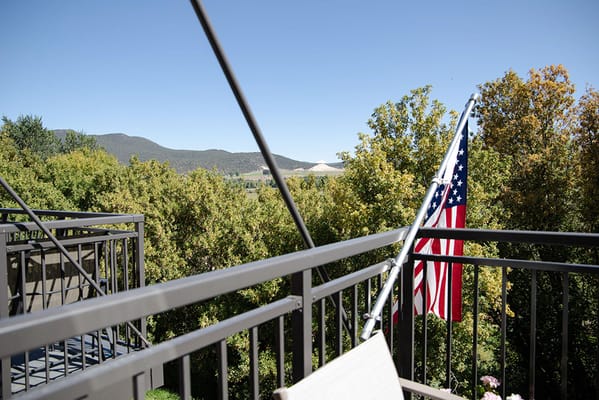 View from a balcony with trees and mountains in the background