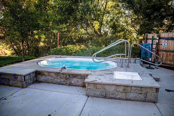 Outdoor hot tub area surrounded by trees