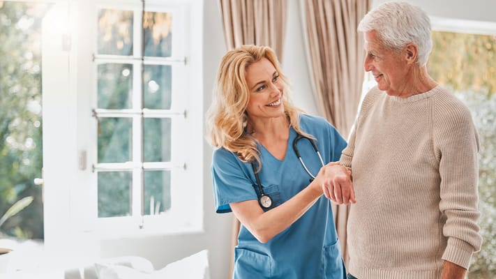A caregiver assisting a senior resident indoors