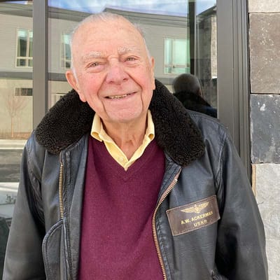Senior resident smiling outside with a jacket