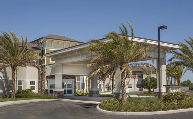 Entrance of Beach House Assisted Living with palm trees