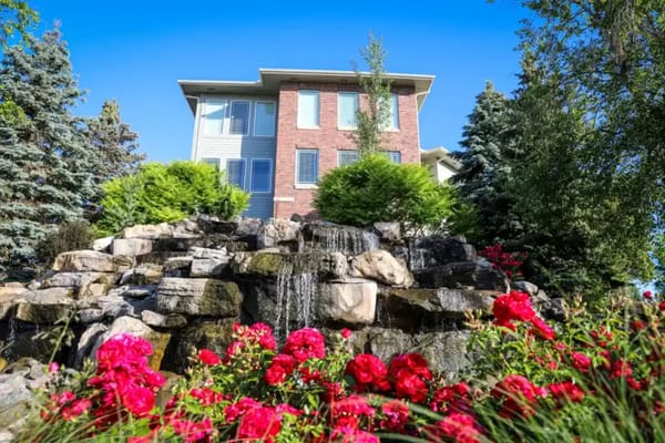 Exterior view of building with landscaped waterfall and flowers