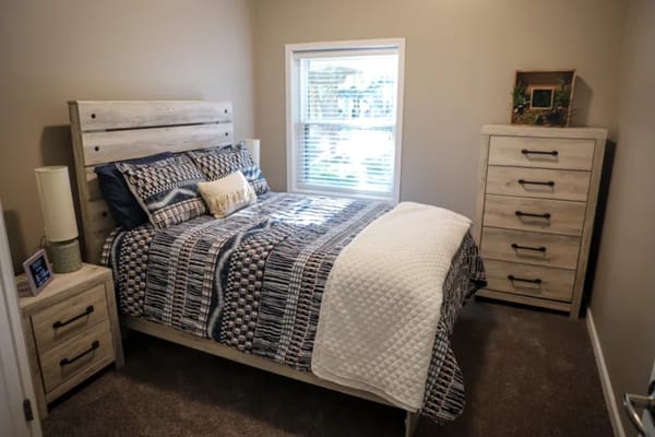 Cozy private resident room with a bed and dresser