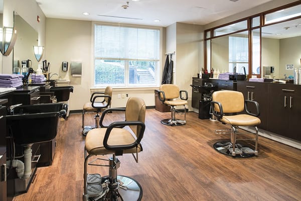 Hair salon with chairs and mirrors inside a facility