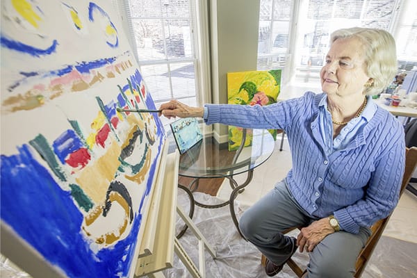 A resident painting in an art activity session