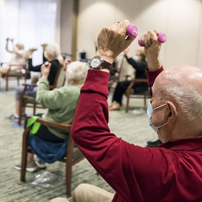 Residents participating in a seated exercise class