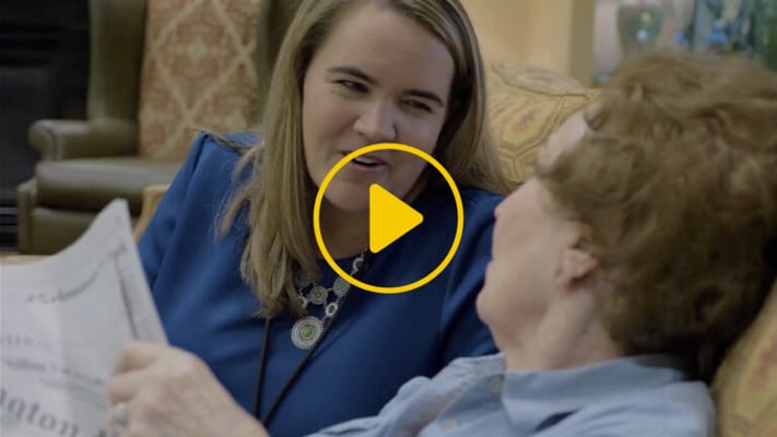 Staff member engaging with a resident in a cozy setting