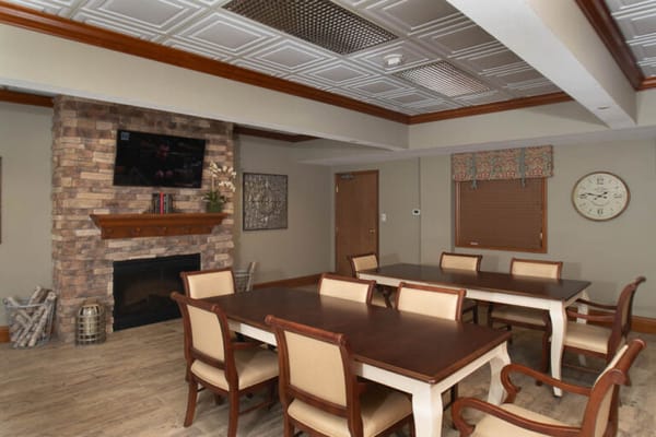 Common area with dining tables and a fireplace