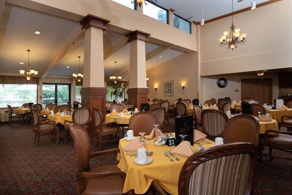 Bright dining room with tables set for residents