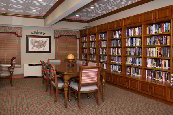 Interior view of a library with bookshelves and a table