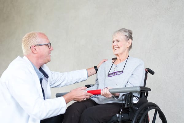 A caregiver assisting a resident in a wheelchair