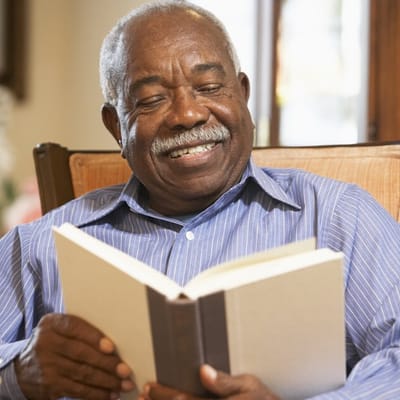 Smiling resident reading a book indoors