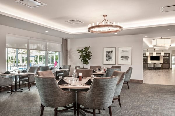 Bright dining room with modern decor and tables set for meals