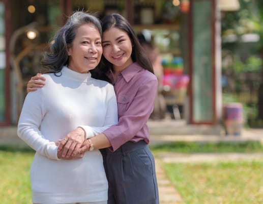 A woman embraces an elderly resident outdoors