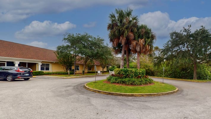 A landscaped outdoor space with palm trees in front of the facility